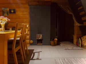 ein Esszimmer mit einem Tisch und einem Kamin in der Unterkunft Ezerkalni in Raiskums