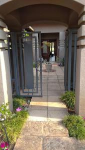 an entrance to a building with a walk way at Cosy home in Pecanwood lake view - Hartbeesport in Hartbeespoort