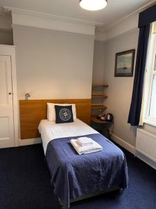a bedroom with a bed with a blue blanket at Royal Temple Yacht Club in Ramsgate