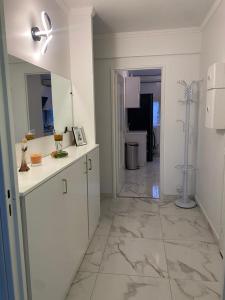 阿讓特伊的住宿－Mon superbe appartement，厨房配有白色橱柜和瓷砖地板。