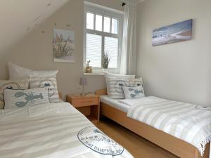 1 Schlafzimmer mit 2 Betten und einem Fenster in der Unterkunft Müggenburger Weg  " Meeresrauschen 2 " in Zingst