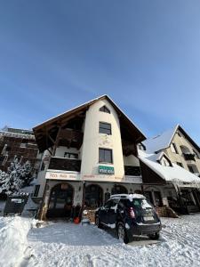 un'auto parcheggiata di fronte a un edificio nella neve di Penzion Verde Rosa a Harrachov