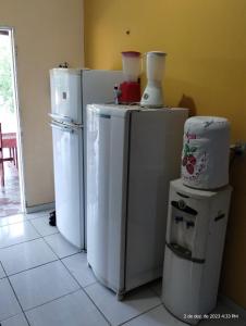 three white refrigerators are sitting in a room at Aconchego do bens in Cruz
