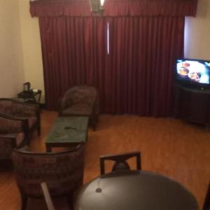 een woonkamer met een tafel en een televisie bij THE WYTE FORT in Ernakulam