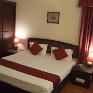 een slaapkamer met een bed met rode en witte kussens bij THE WYTE FORT in Ernakulam