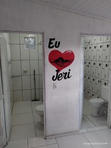 a bathroom with a door with a red heart on it at Aconchego do bens in Cruz