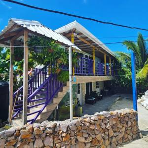 a house on the beach with purple stairs at Posada Cedar Valley in Providencia