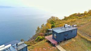 Şarköy的住宿－Carpe Diem (Rose)，水边小山上的蓝色房子