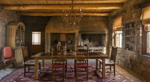 a dining room with a wooden table and chairs at Sneeuberg Nature Reserve in Nieu-Bethesda