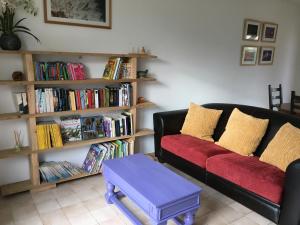 ein Wohnzimmer mit einem Sofa und einem Bücherregal voller Bücher in der Unterkunft Maison de vacances au calme in Angles