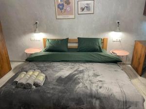 a bedroom with a large bed with two tables at Уютная студия в центре Кишинёва in Chişinău