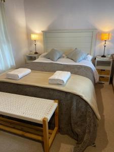 dwa łóżka w pokoju z dwoma stołami i lampami w obiekcie Otto House w mieście Bariloche