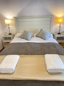 duże łóżko z dwoma poduszkami na górze w obiekcie Otto House w mieście Bariloche