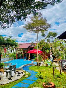 un complexe avec une piscine et un parasol rouge dans l'établissement Homestay Làng Tôi - Pleiku - Gia Lai, à Plei Brêng