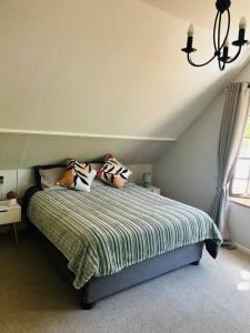 Un dormitorio con una cama con almohadas. en The Olive Tree Cottage, en Riebeek-Wes