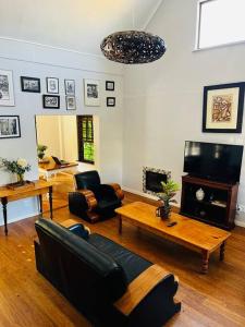 a living room with a couch and a table at The Olive Tree Cottage in Riebeek-Wes