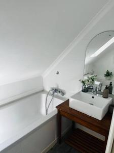 a white bathroom with a sink and a mirror at The Olive Tree Cottage in Riebeek-Wes