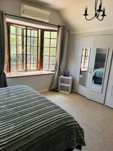 a bedroom with a bed and a large window at The Olive Tree Cottage in Riebeek-Wes