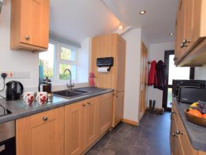 una cocina con armarios de madera y fregadero en 1 bed in Taunton 49569 en Hatch Beauchamp