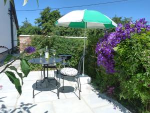 una mesa y sillas bajo una sombrilla junto a flores púrpuras en 1 bed in Taunton 49569 en Hatch Beauchamp