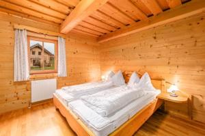 una camera con un letto in una baita di tronchi di Chalet Dachsteinblick a Pruggern