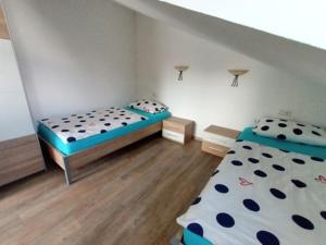 ラーベンスブルクにあるGrünkraut Salzgeberのベッド2台と階段が備わる小さな客室です。