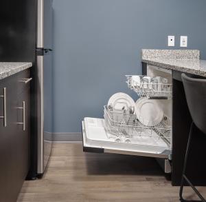 a dishwasher with dishes in it in a kitchen at stayAPT Suites Auburn in Auburn