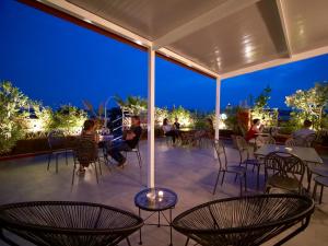 a patio with tables and chairs at night at Hotel Casa Valdese Roma in Rome