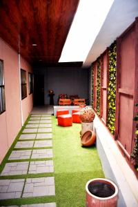 um pátio com relva verde e mobiliário vermelho num edifício em BAMBOO LODGE - la Criquet 'Event' em Lomé