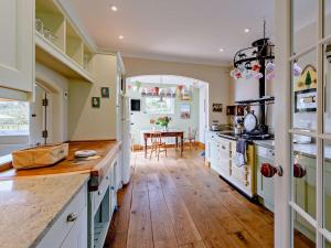 uma cozinha com armários brancos e piso em madeira em 5 Bed in Instow 54485 em Instow