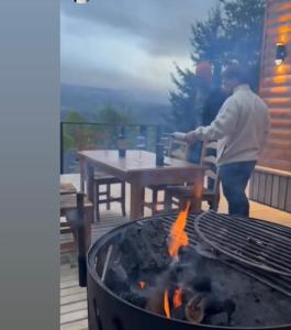 un hombre está parado junto a una parrilla en Horizonte Chapelco en San Martín de los Andes