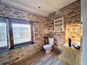 a stone bathroom with a toilet and a window at Studio Duplex Calme-Parking-Wifi in Comps-la-Grand-Ville