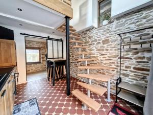 a room with a brick wall and wooden stairs at Studio Duplex Calme-Parking-Wifi in Comps-la-Grand-Ville