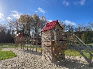 a wooden playground with a slide and a play structure at Holiday Home Jägerwiesen-8 by Interhome in Waldkirchen