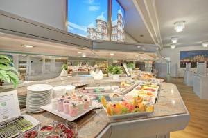 a buffet line with food on display in a restaurant at Ambassador TheContinents in Karlsruhe