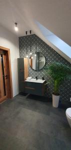 a bathroom with a sink and a mirror on a wall at Willa ViWaldi Janowa Góra in Sienna