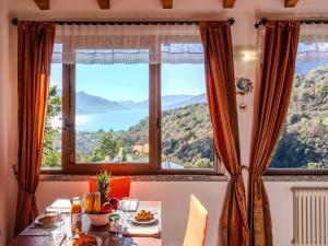 une salle à manger avec une table et une grande fenêtre dans l'établissement Holiday Home Ca' Ermy by Interhome, à Consiglio di Rumo