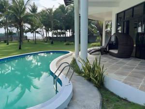 uma piscina ao lado de uma casa com um baloiço em Luxury Villa: Private Pool & Beach Retreat em Boracay