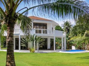a white house with a palm tree in front of it at Luxury Villa: Private Pool & Beach Retreat in Boracay