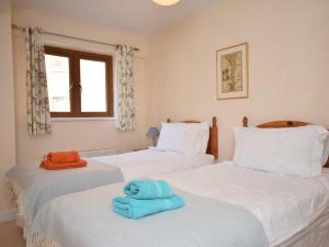 two beds with a blue towel sitting on them at 2 Bed in Westward Ho OCE16 in Westward Ho