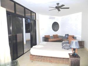 Luxury Villa: Private Pool & Beach Retreat في بوراكاي: غرفة نوم بسرير ومروحة سقف