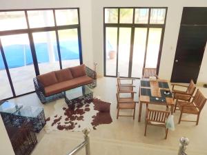 een woonkamer met een bank en een tafel en stoelen bij Luxury Villa: Private Pool & Beach Retreat in Boracay