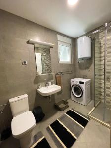 een badkamer met een wastafel en een wasmachine bij Sunny apartment in Tivat in Tivat