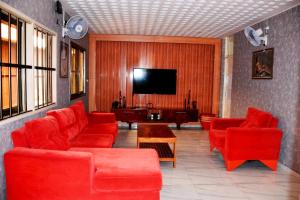 a living room with red furniture and a flat screen tv at BAMBOO LODGE - la Criquet 'Event' in Lomé
