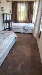 a room with two beds and a window at Doornspruit Farm in Magaliesburg