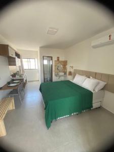 Un dormitorio con una cama con una manta verde. en Flor de Cacto Beach Home en São Miguel do Gostoso