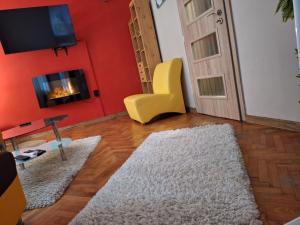 a living room with a fireplace and a yellow chair at Cozy apartment in the heart of Sofia in Sofia
