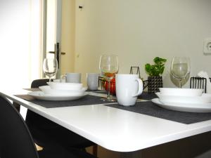 a table with white plates and wine glasses on it at Melia Luxury Studio in Thessaloniki