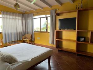 a bedroom with a bed and a flat screen tv at Suites La Hacienda in Puerto Escondido