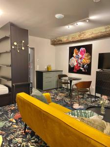 a living room with a yellow couch and a table at Pebbles Suiten by RiNG in Regensburg